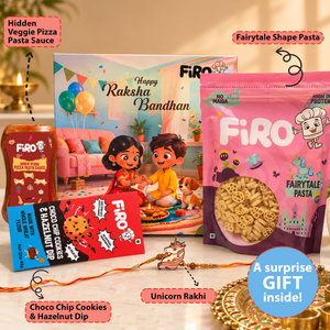 A festive gift set for Raksha Bandhan from Firo, featuring a pink bag of Fairytale Pasta, a bottle of Hidden Veggie Pizza Pasta Sauce, a box of Happy Raksha Bandhan, a pack of Choco Chip Cookies & Hazelnut Dip, and a unicorn-themed Rakhi on a decorated table with text callouts.